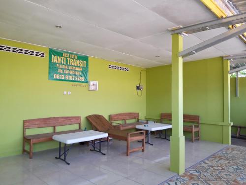 a waiting area with benches and tables in a restaurant at Janti Transit Room Syariah in Yogyakarta