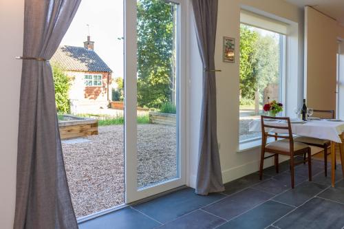 a door leading to a garden with a table and chairs at Robin's Egg in Aldeburgh