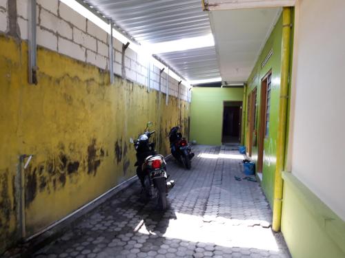 twee motorfietsen geparkeerd in een hal van een gebouw bij Janti Transit Room Syariah in Yogyakarta