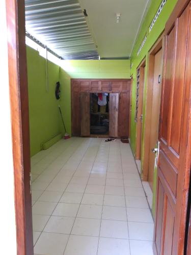 een lege kamer met groene muren en een witte tegelvloer bij Janti Transit Room Syariah in Yogyakarta