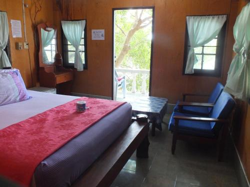 een slaapkamer met een bed, een tafel en een stoel bij Queen Resort Koh Tao in Ko Tao