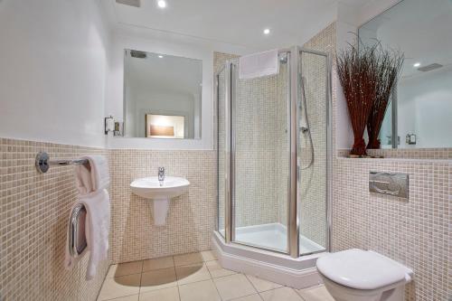 W łazience znajduje się prysznic, toaleta i umywalka. w obiekcie 2 bed 2 bath at Jago Crt in Newbury - FREE allocated parking w mieście Newbury