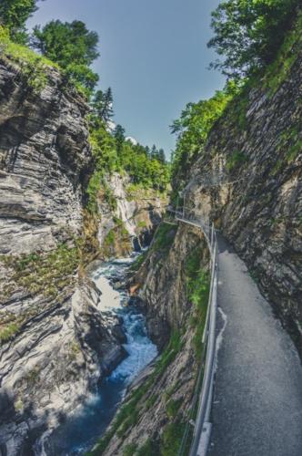 a road on the side of a mountain next to a river at dala Hotel & Apartments in Leukerbad