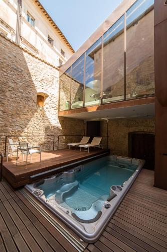 a hot tub on a deck next to a building at Palazzo Neri in Trevi