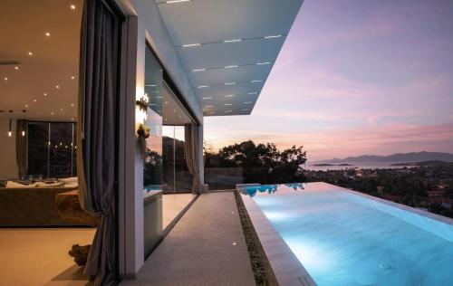 a house with a swimming pool with a view at Magic suites Seaview villas, Koh Samui in Choeng Mon Beach