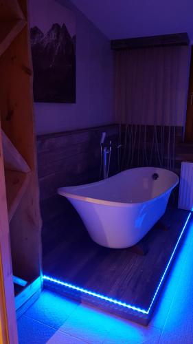 a white tub in a bathroom with a blue light at Kompleks Małe Dolomity in Hucisko