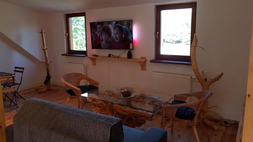 a living room with a glass table and chairs at Kompleks Małe Dolomity in Hucisko