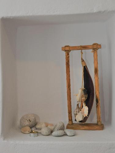 a shelf with rocks and a picture of a boat at Andria's suites in Chrissi Akti