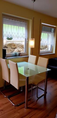 a dining room with a glass table and white chairs at Apartment Hallstadt in Hallstadt