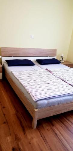 ein großes Bett in einem Zimmer mit Holzboden in der Unterkunft Apartment Hallstadt in Hallstadt