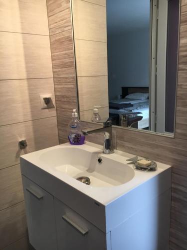 W łazience znajduje się biała umywalka i lustro. w obiekcie Bruno Apartment w Klużu-Napoce