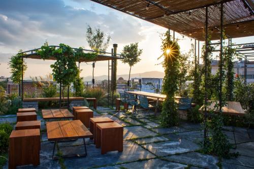 a patio area with tables, chairs and umbrellas at The Foundry Suites in Athens