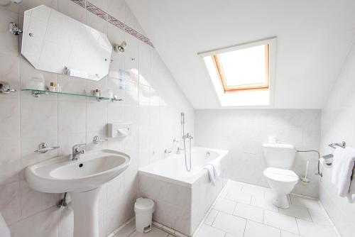 a white bathroom with a sink and a toilet at Monti Spa in Františkovy Lázně