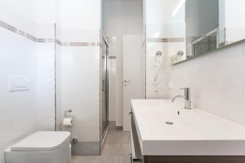 La salle de bains est pourvue de toilettes, d'un lavabo et d'une douche. dans l'établissement Laterani Guest House, à Rome