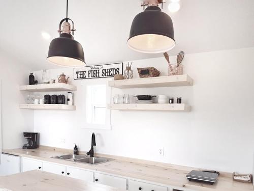 a kitchen with two lights and a sink at The Fish Sheds in Rocky Harbour