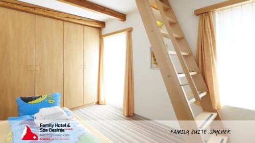 a bedroom with a bunk bed and a ladder at Family Hotel Desirée in Grächen
