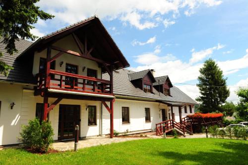 a large white house with a gambrel roof at Wellness Hotel Holzberg in Suchá Rudná