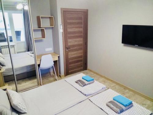a room with a bed and a television and two towels at Apartment for rent in the city center of Kharkiv K18 Elinaflats in Kharkiv