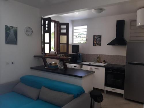 a kitchen with a blue couch in a room at location guadeloupe in Le Gosier