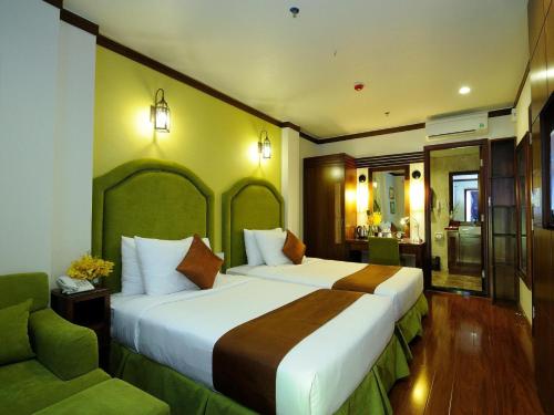 a hotel room with two beds and a couch at Asian Ruby Boutique Hotel Bùi Thị Xuân in Ho Chi Minh City