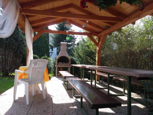 a wooden picnic table and bench under a wooden pergola at Rekreacny Dom in Strečno
