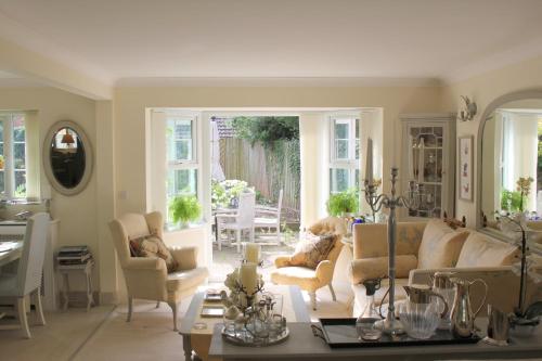 a living room with a couch and chairs and a table at Harlequin B&B Ledbury in Ledbury