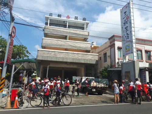 a group of bicyclists standing in front of a building at San He Inn in Taimali