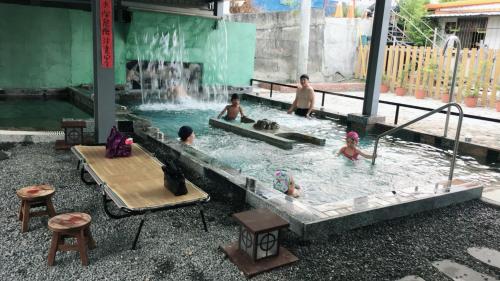 a group of people in a swimming pool with a waterfall at San He Inn in Taimali
