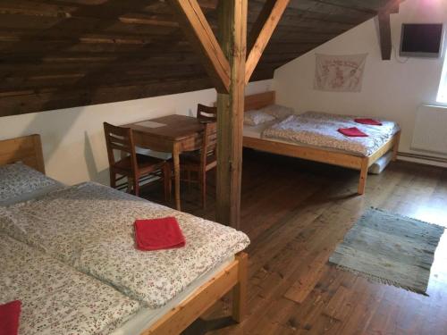 a room with two beds and a table and a table and chairs at Penzion Olesnice in Zlatá Olešnice