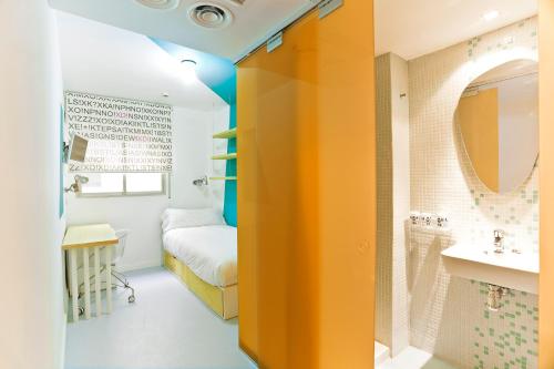 Habitación con cama y baño con espejo. en Students XD, en Granada