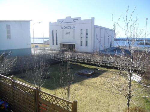 a white building with a fence in front of it at Teigur Guesthouse in Akranes