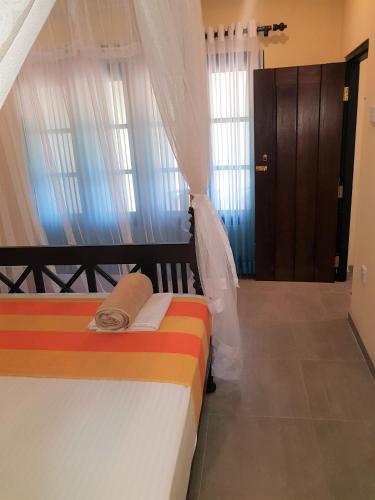 a bedroom with two beds and a door with windows at Villa Gaetano Unawatuna in Unawatuna