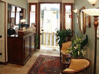 a living room with a desk and chairs and a rug at Locanda Gaffaro in Venice