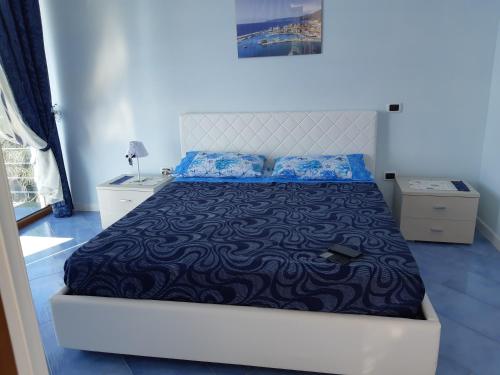 a bedroom with a large bed with blue sheets at Casa Notaro Sorrentino in Acciaroli