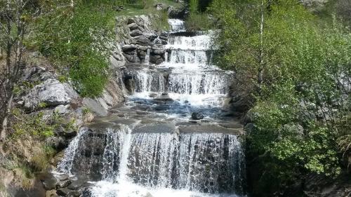 a waterfall on the side of a mountain at Montagne Duplex-Orelle 9 pers. avec SPA in Orelle