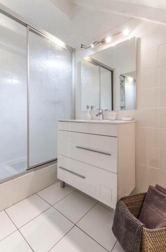 une salle de bain blanche avec un lavabo et un miroir dans l'établissement Villa Saint-Georges, à Vesoul