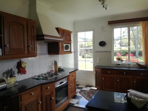 a kitchen with wooden cabinets and black counter tops at Quinta do Sossego in Pico da Pedra