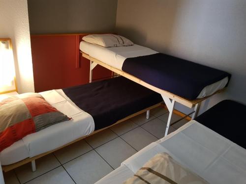 a room with two bunk beds in a room at Hôtel Eco Logis Espace Bellevue in Séméac