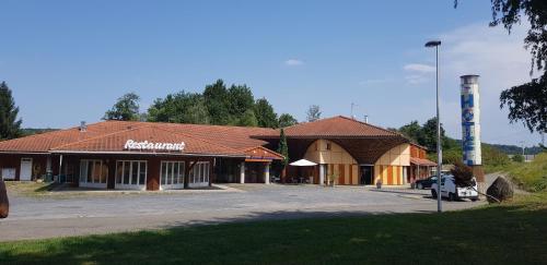 a building with a sign on the side of it at Hôtel Eco Logis Espace Bellevue in Séméac