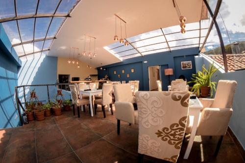 a dining room with skylights and a table and chairs at Cooper Hotel Boutique in Cusco