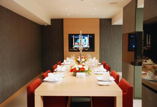 a dining room with a long table and red chairs at Met Hotel in Izmir