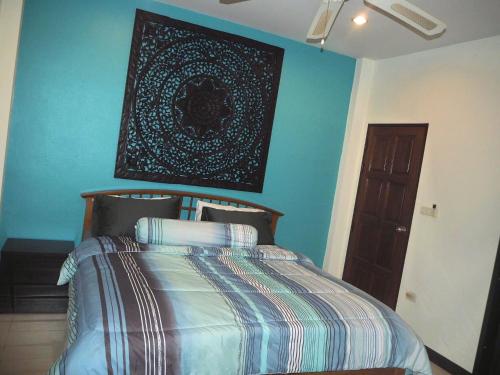 1 dormitorio con 1 cama con una foto en la pared en Beautiful 3 Bedroom Garden Villa, en Chalong 