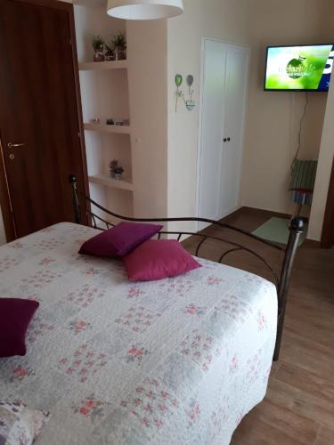 a bedroom with a bed with purple pillows on it at B&B La Dolce Sosta in Fonni