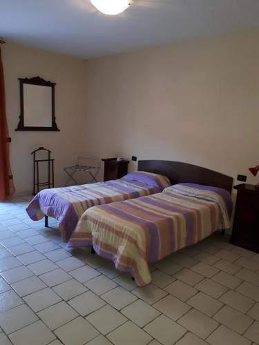 Castellafiume的住宿－Lo Scoiattolo，一间卧室设有两张床,墙上设有一面镜子