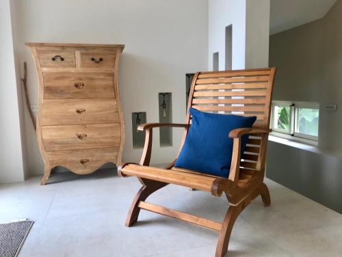 a wooden rocking chair with a blue pillow at 飲山風民宿 in Jian