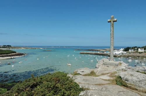 a large body of water with a cross on the rocks at Letard Murielle in Ploudalmézeau