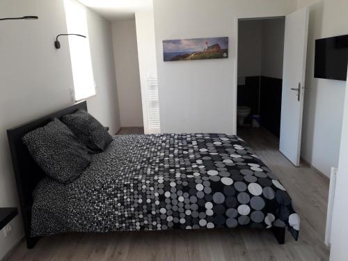 a bedroom with a bed with a black and white comforter at Letard Murielle in Ploudalmézeau