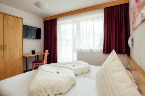 a hotel room with two beds and a window at Apart Luneta in Ladis