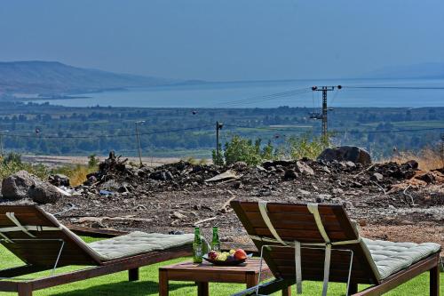 two chairs and a table with a bowl of fruit at shmulik's resort couples or families only in Had Nes