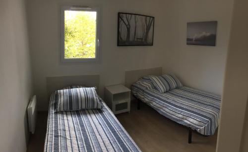 Habitación con 2 camas y ventana en Maison Lore Mendi Amotz, en Saint-Pée-sur-Nivelle
